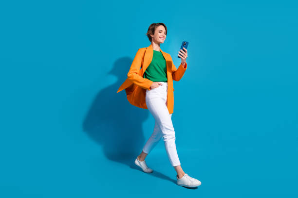 Full body size cadre of young optimistic project manager nice woman student communicating phone chat isolated on blue color background stock photo