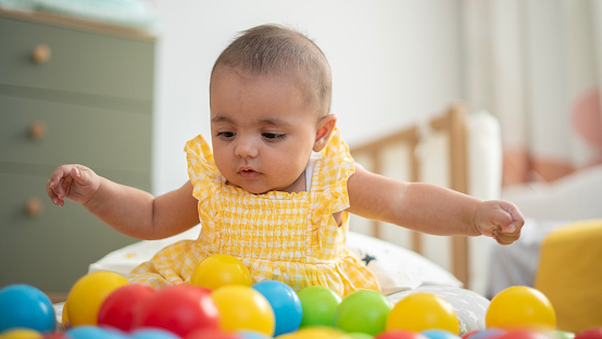 Sweet baby girl playing with colorful balls