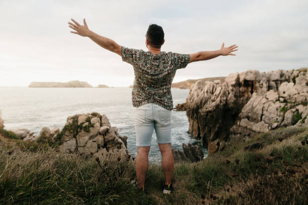 istock Man with arms raised by the sea 1652578098