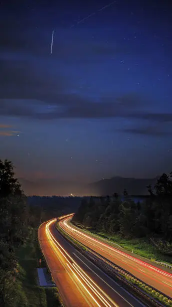 composit lighttrails motorway with nightsky and meteors