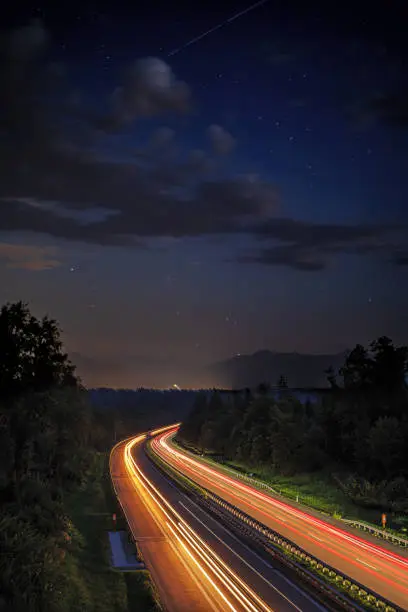 composit lighttrails motorway with nightsky and meteors