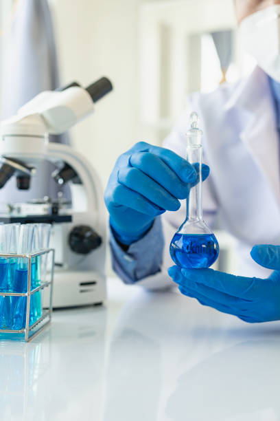 istock Researchers, scientists work in vitro analysis with blue liquids in chemical science laboratories or experimental technology, medical biology. Remote Picture Vertically 1652614985