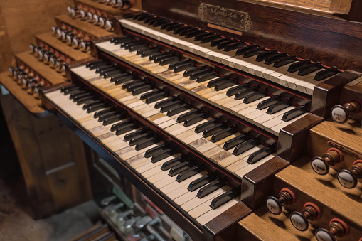 Manuals, pedalboard and many registers. Classical music, conservatory and sacred music. Old wooden organ connected to pipes.