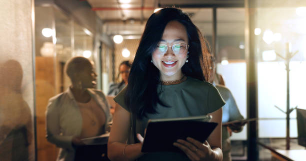 istock Night, tablet and business people walking in office after finishing work task. Tech, overtime and Asian woman with group of friends going home after working late on sales project in dark workplace. 1652684025