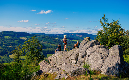 Family, mother and children on top of rocks enjoying panoramic landscape view- Morvan in France