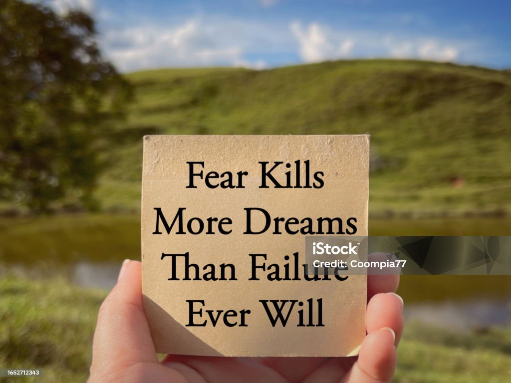 Motivational and inspirational wording. Fear Kills More Dreams Than Failure Ever Will written on a notepad. With blurred styled background. Inspirational Quote Stock Photo