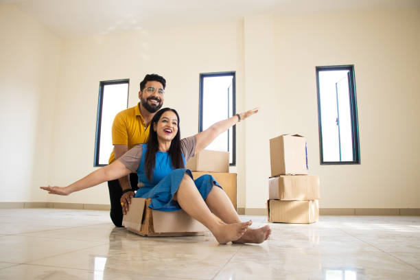 feliz joven pareja india divirtiéndose en un nuevo hogar. jugando con cajas, bienes raíces, hipoteca residencial, mudarse al concepto de casa de ensueño. - moving house physical activity real estate couple fotografías e imágenes de stock