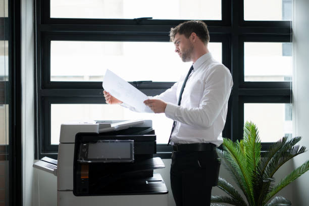 istock Businessman in office working with copier. 1652719623