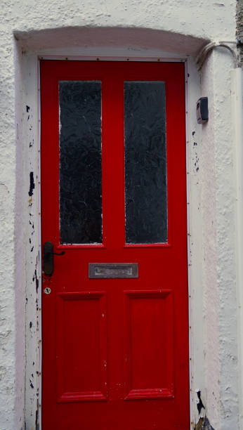 une porte d’entrée résidentielle rouge au royaume-uni avec une boîte aux lettres et du verre - doorstep door knocker door england photos et images de collection