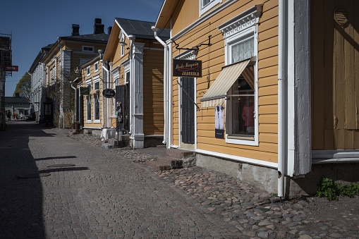 A row of timber constructed buildings on a residential street, illuminated by the warm glow of the setting sun