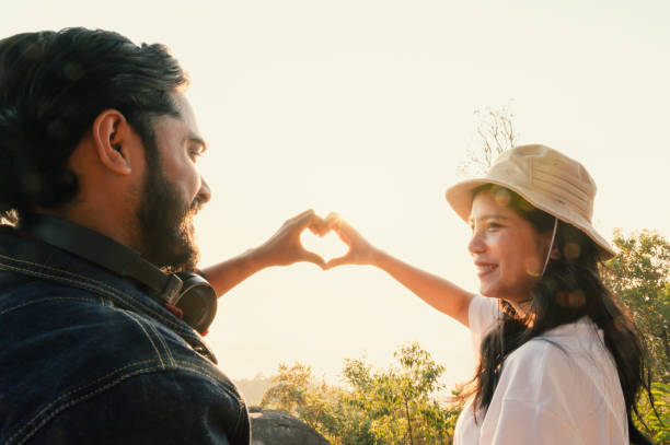 istock traveler couple hand shape heart over sunset 1652766019