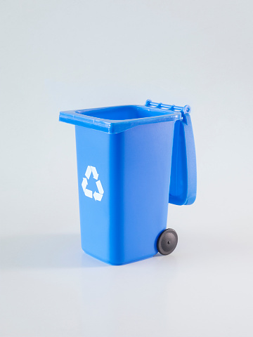 An opened metal trash can or waste bin blue colored on white background