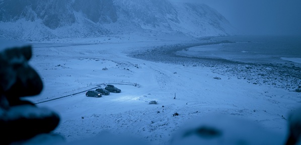 Three cars parked in a wintery landscape, surrounded by a blanket of snow
