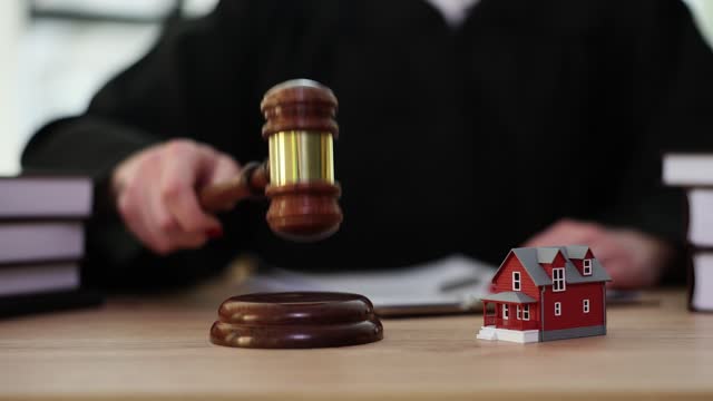 Judge knocks judge wooden gavel on background of house