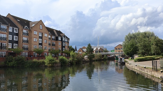 A peaceful residential area, with a paved path running alongside a tranquil canal in Apsley