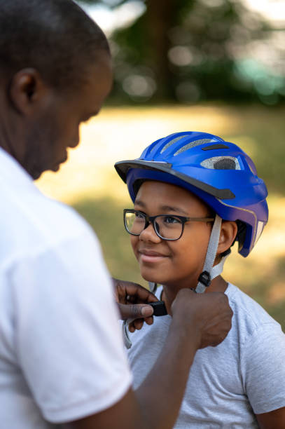 istock Dad fixing a protective hemlet on his kids head 1652804371