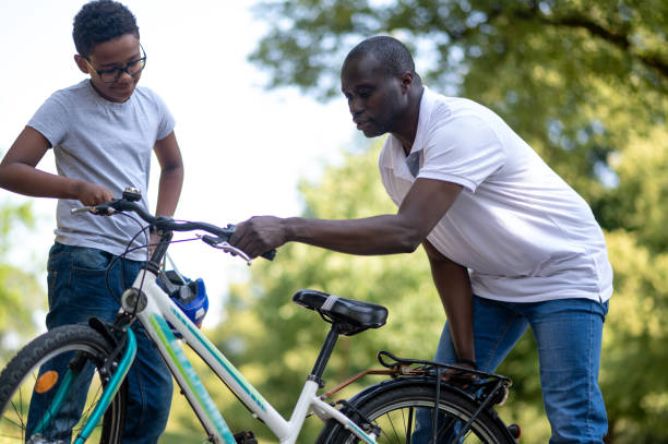 istock Dark-skinned man fixing a bike in the park 1652805720