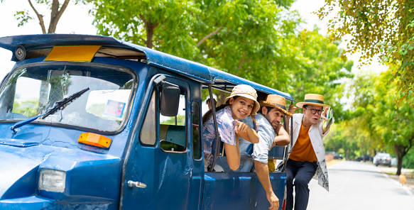 Group of Diversity people traveler travel Ayutthaya Province in Thailand on summer holiday vacations. Asian man local tour guide and tourist travel architecture and old ruin temple famous place by Auto rickshaw or tuk tuk taxi.