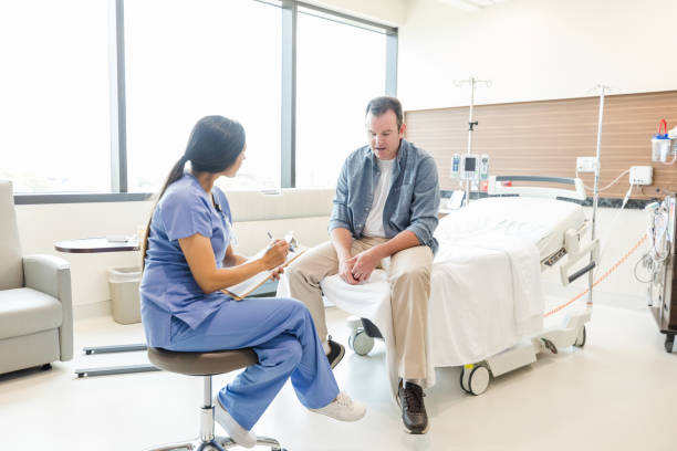 istock Male patient looks down while talking to female ER doctor 1652856448