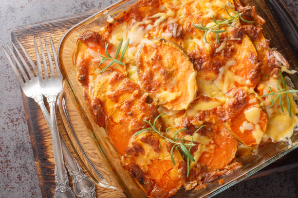 homemade sweet potato gratin with cheddar cheese, eggs and rosemary close-up in a glass form. horizontal top view - food sweet potato yam vegetable imagens e fotografias de stock