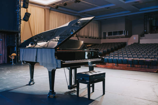 grand piano on stage facing empty theatre auditorium