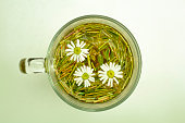 Glass mug with chamomile tea.