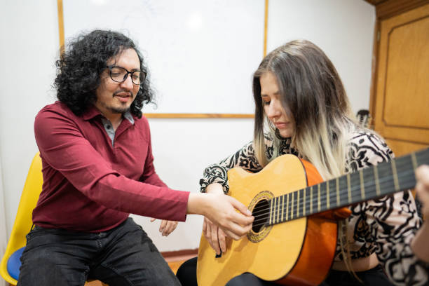 istock Teacher teaching acoustic guitar to his student indoors 1652934676
