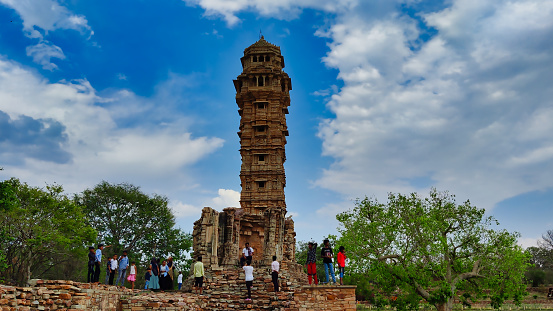 Chittorgarh, India 7 May 2023: Picture of Vijay Stambha at Chittorgarh Fort shot during daylight against blue sky and white clouds
