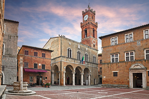 Pienza, Siena, Tuscany, Italy: the main square with the ancient city hall and the beautiful water well of the picturesque medieval town