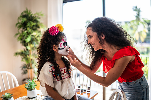 Happy mother and daughter talking before celebration of the day of the dead