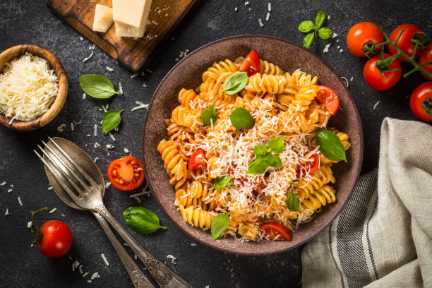 istock Italian pasta alla arrabiata with basil and parmesan cheese on dark stone table. 1653002170
