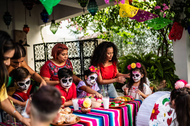 niños y sus madres poniendo decoraciones en una mesa para la celebración del día de la muerte - haunted house house spooky real estate fotografías e imágenes de stock