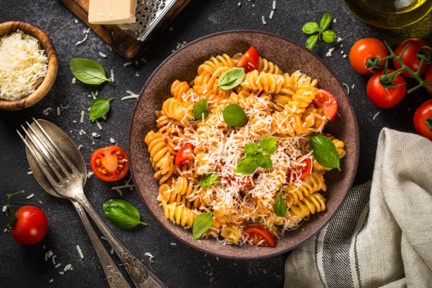 istock Italian pasta alla arrabiata with basil and parmesan cheese on dark stone table. 1653011630