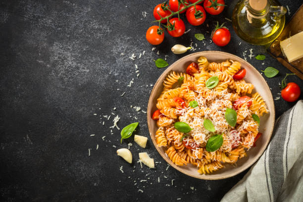 istock Italian pasta alla arrabiata with basil and parmesan cheese on dark table. 1653016439