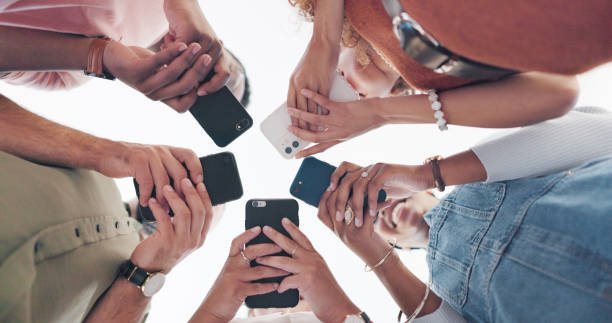 istock Hands, phone and communication with friends standing in a huddle or circle from below for networking. Social media, mobile and 5g with a man and woman friend group connected to the internet together 1653030243