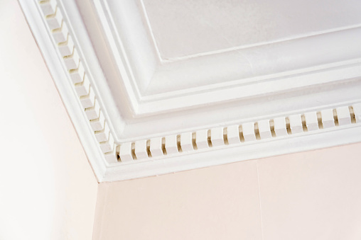 The cornice plasterwork at the corner of a room.