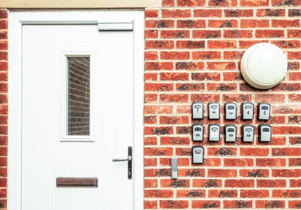 Lockboxes for short-term rental apartments A main door to an apartment block in England, with a series of combination code lockboxes containing keys for different apartments, used for short term bed and breakfast rental. key package stock pictures, royalty-free photos & images