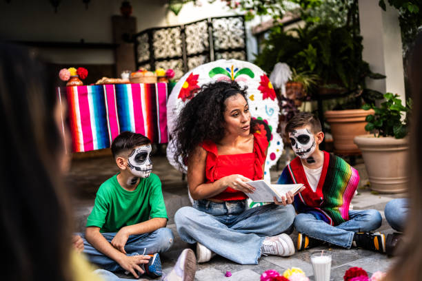 madre leyendo un libro a los niños durante un día de celebración de la muerte - haunted house house spooky real estate fotografías e imágenes de stock