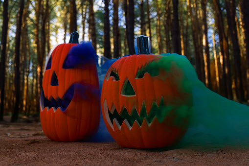 Halloween pumpkin with green and blue smoke. Halloween pumpkin. Autumn background.