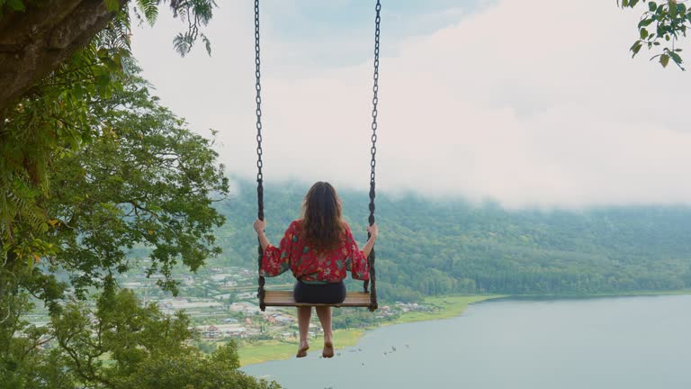 Woman on the swing above the lake on Bali