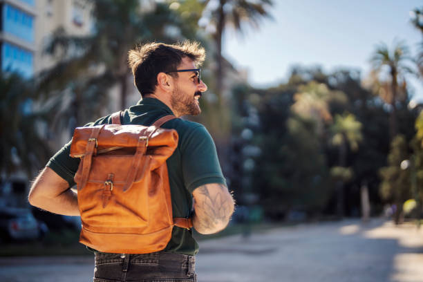 istock Back view of a man with rucksack visiting European metropolis. 1653112683
