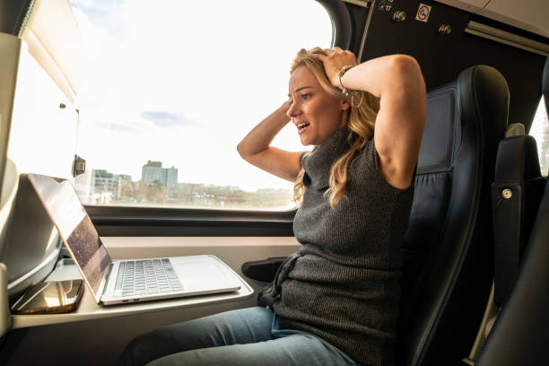 eine frau an einem laptop in einem zug - leaving loneliness women railroad track stock-fotos und bilder
