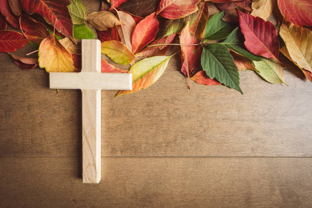 istock Wood cross with autumn leaf border on wood 1653123610