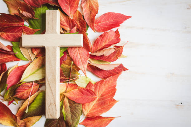istock Wood cross with autumn leaf border on a white background 1653124779