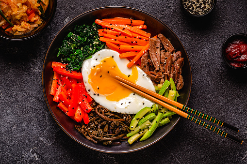 Traditional Korean dish Bibimbap: rice with vegetables beef and egg, top view.