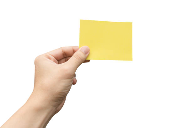istock Hand holding yellow paper isolated on white 1653146101