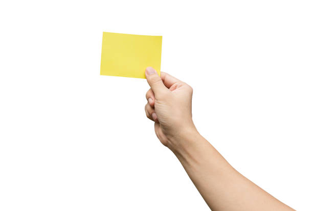 istock Hand holding yellow paper isolated on white 1653148874