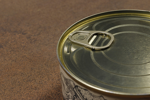 Close-up of a closed tin can with a key to open it.