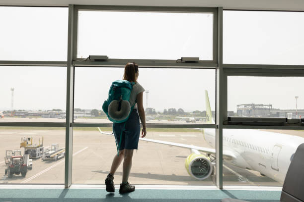 istock Female tourist watching airplanes while waiting for her flight 1653161649