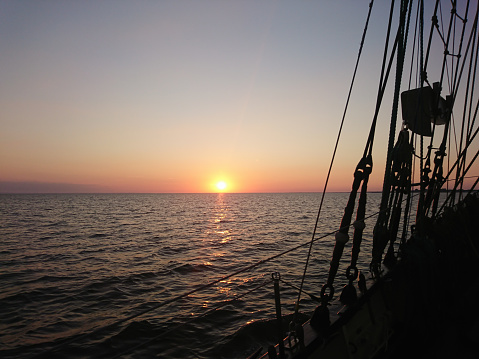 Sunset at sea from the deck of a sailing ship
